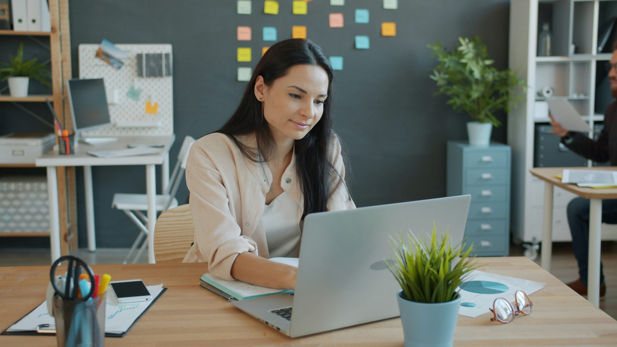 Woman Looking at Compuer while working in the office Woamn working in teh office on a laptop